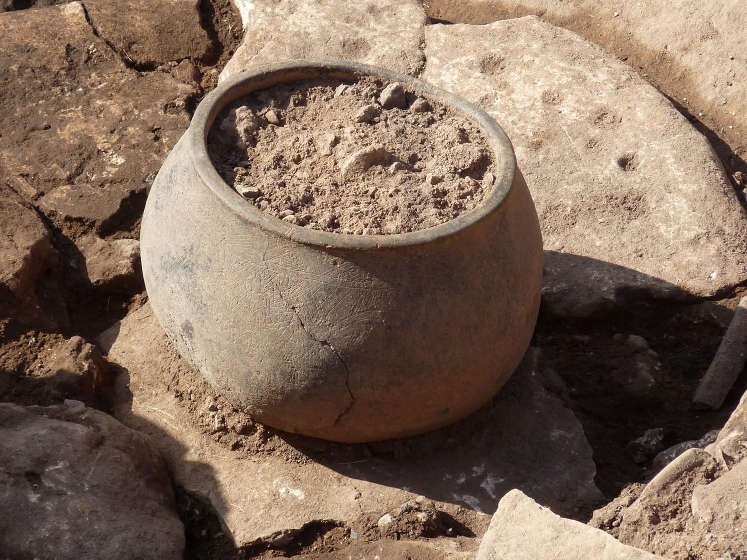A small stone vessel at Karahan Tepe, photographed as it emerged in the excavation — the same stone-carving tradition, 40 km east of Göbekli Tepe.
