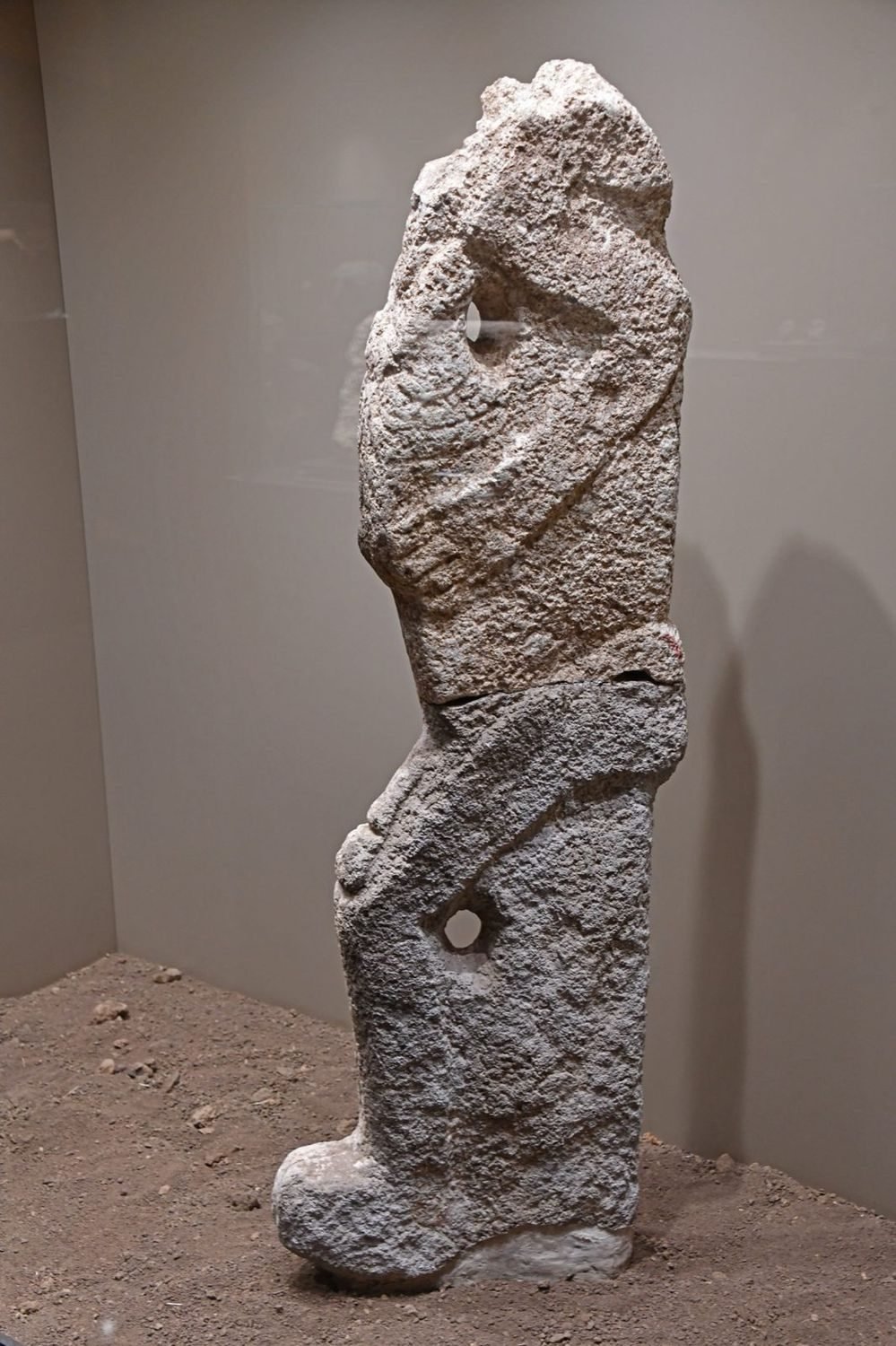 A seated human statue from Karahan Tepe, now in the Şanlıurfa museum — the same population of beings rendered as free-standing sculpture rather than as a pillar.
