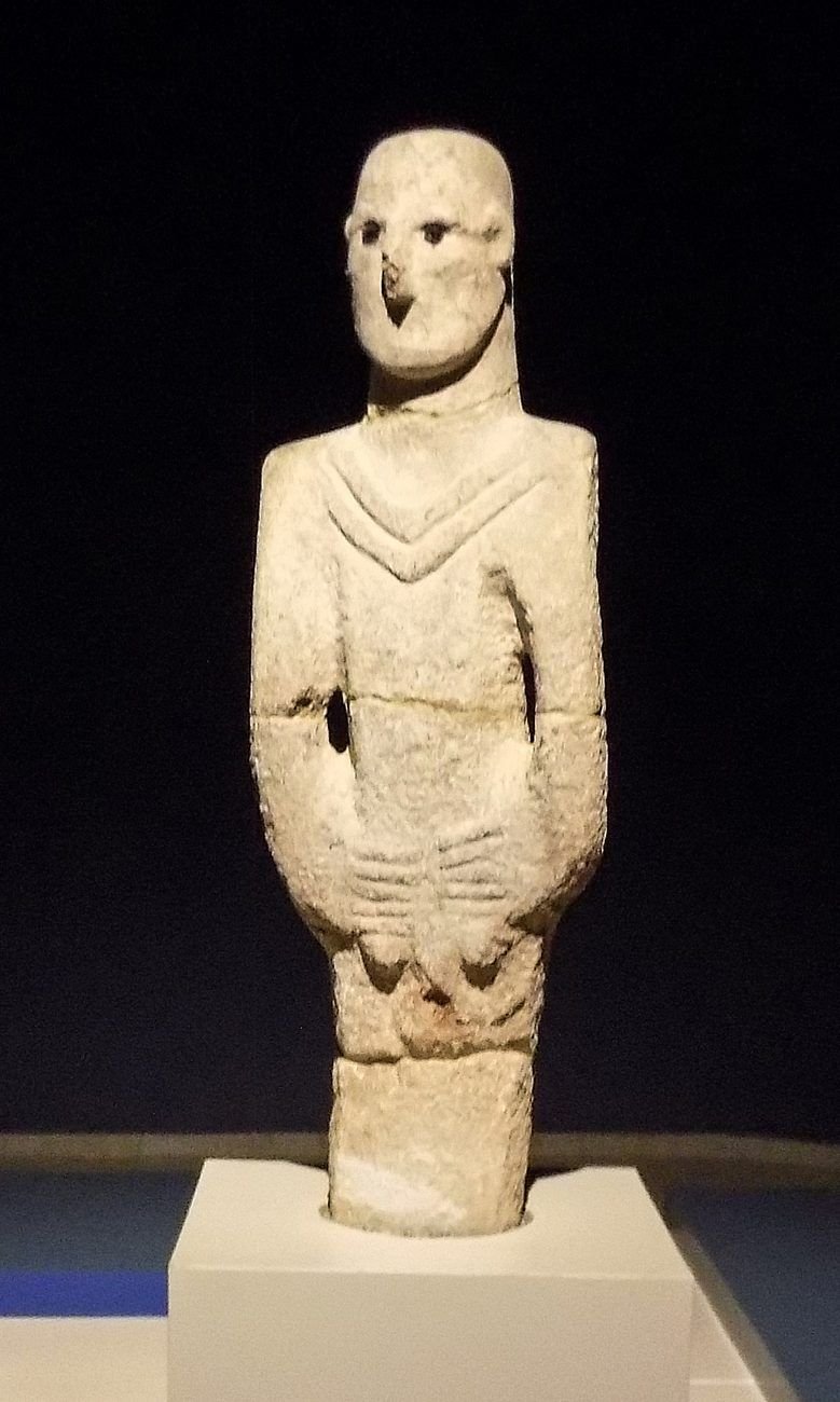 The whole figure, about 1.8 metres tall — a standing man carved from a single block of limestone, ending in a plain peg below the hands rather than legs and feet. He is displayed in the Şanlıurfa Archaeology Museum.