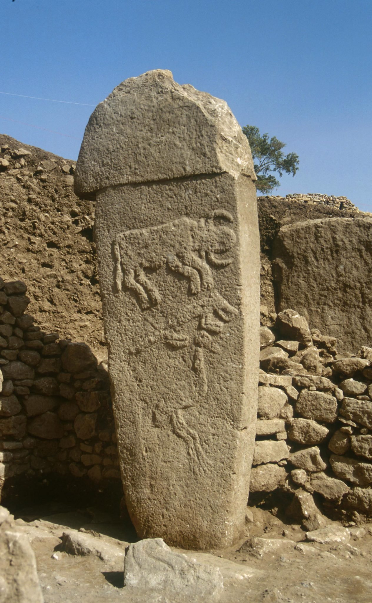 Pillar 2 in Enclosure A at Göbekli Tepe, carved with reliefs of an aurochs, a fox and a crane.