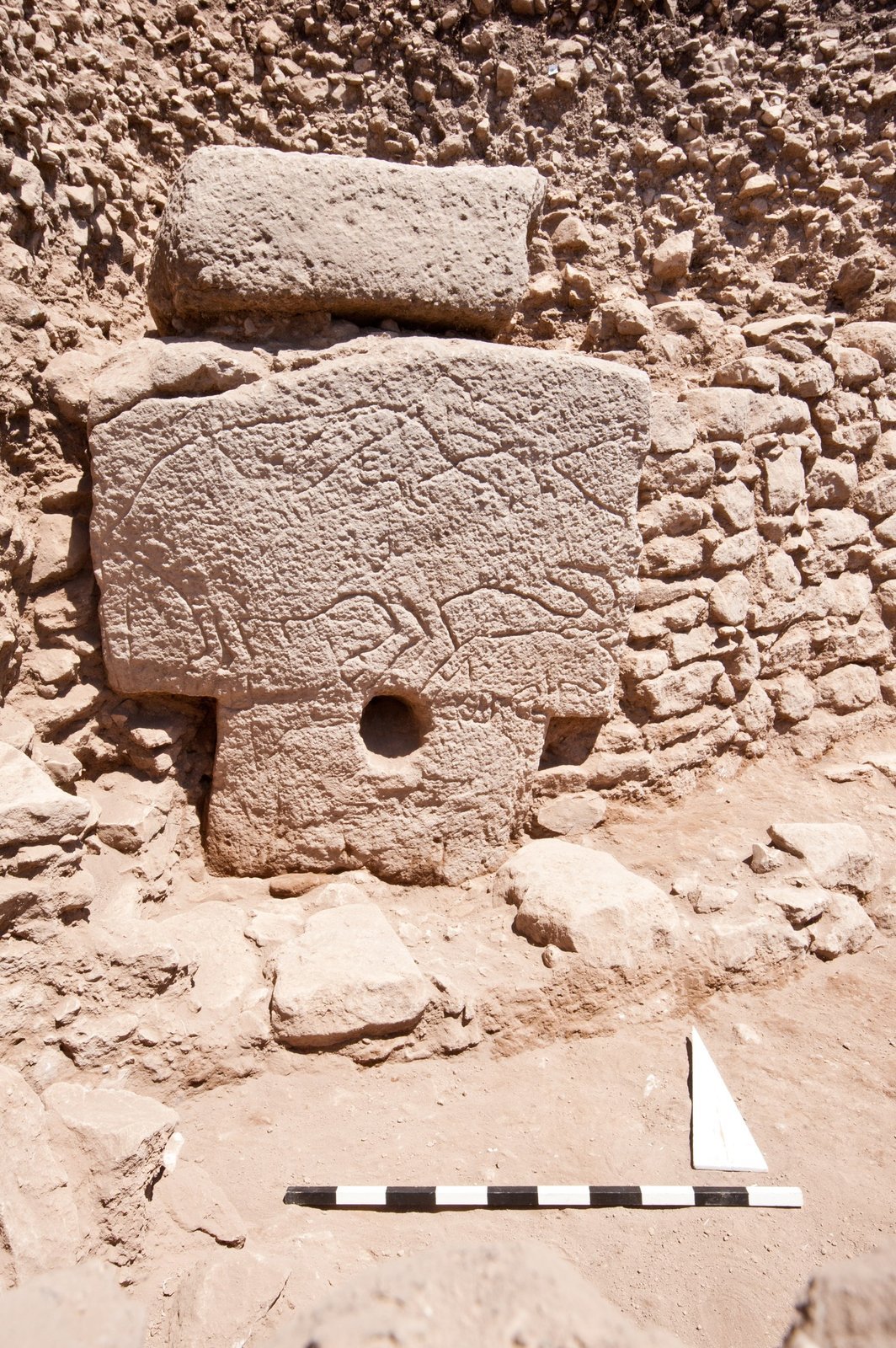 Pillar 66 of Enclosure H with a scratched horned animal and a round opening