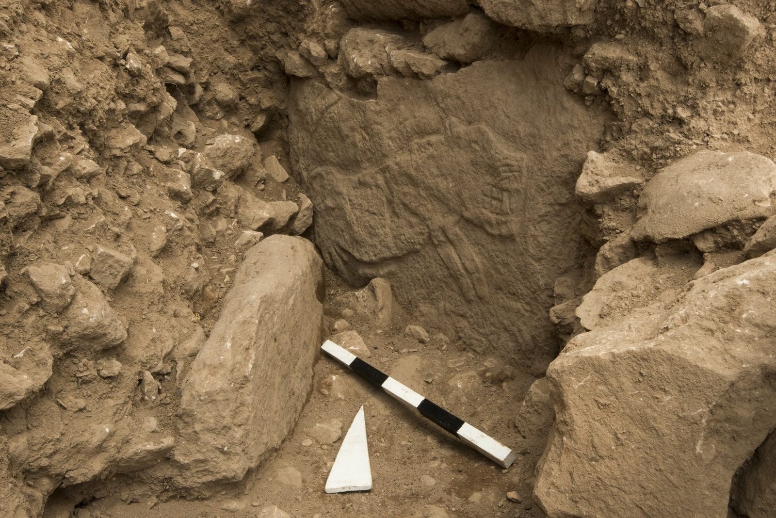 Pillar 69 of Enclosure H, a partly buried pillar with a faint eroded relief