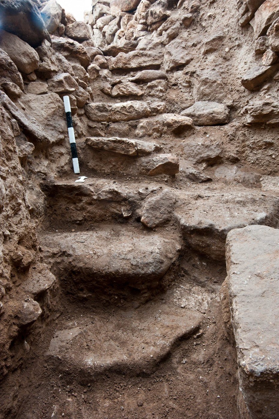 Excavated stone steps of a stairway in the entrance area of Enclosure D, with a black-and-white scale bar