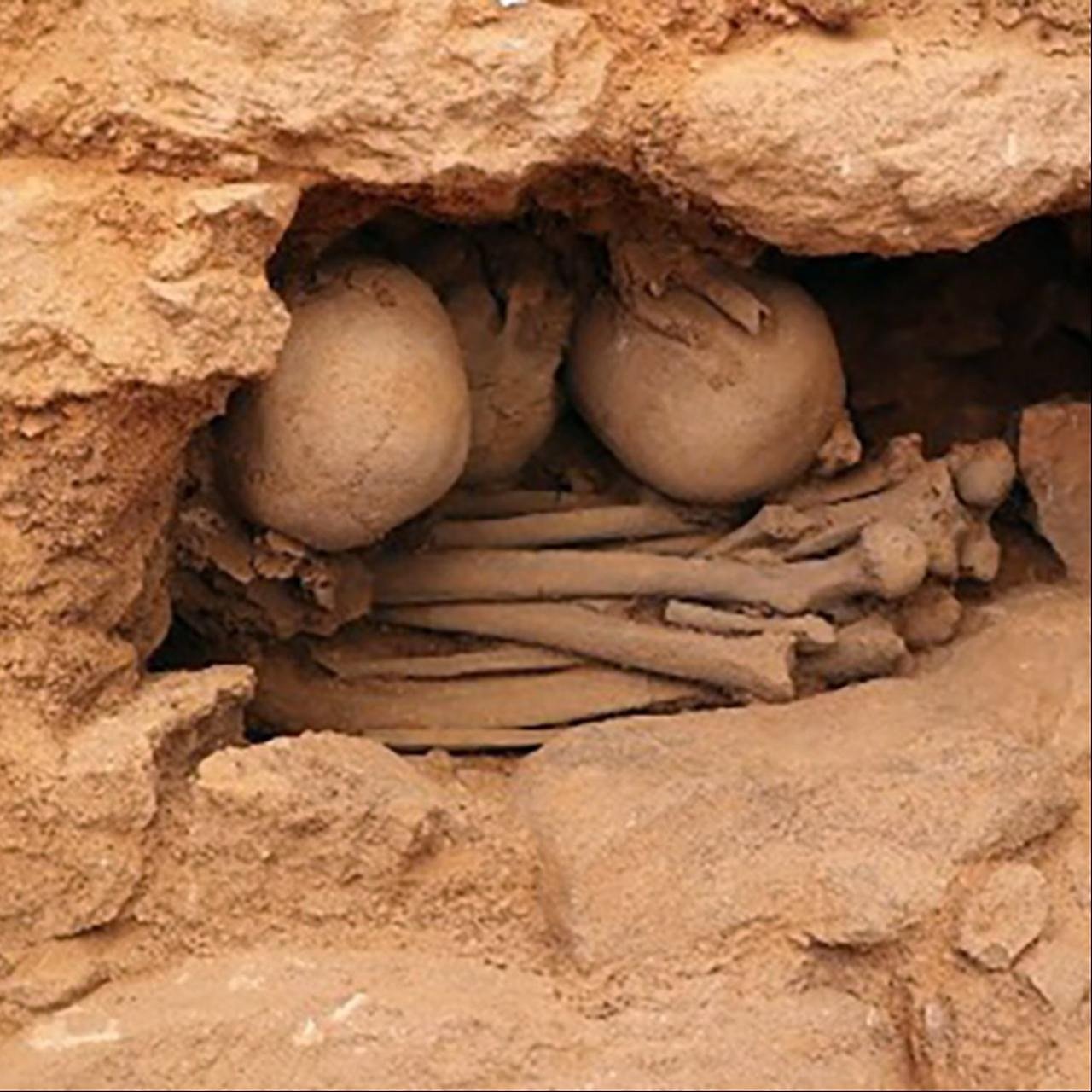 A secondary burial deposit — skulls grouped with long bones, the dead reduced to curated bone rather than laid out whole. Some Neolithic skulls of the wider region were given inset eyes of shell (as at Jericho far to the south), hinting the treatment of the head was a broad regional practice, not a single-site cult.
