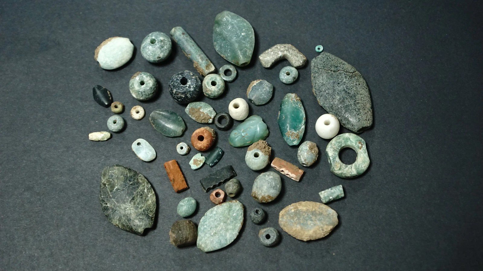A typological plate of Sefertepe beads and pendants sorted into rows by shape and size